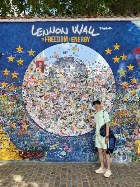 레논 월(Lennon Wall) 앞에서 포즈. 