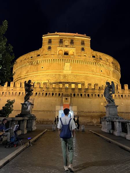 성천사성(Castel Sant'Angelo) 야경. 금빛 조명에 빛나는 원형 성. 앞에서 포즈를 취하고 있다. 밤하늘 아래 성이 황금빛으로 빛난다